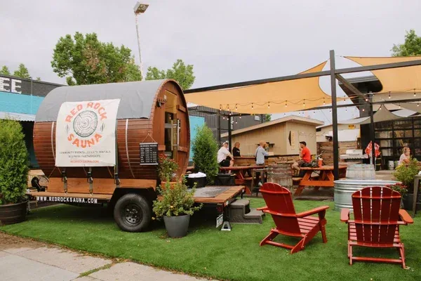Barrel sauna on a trailer with outdoor chairs