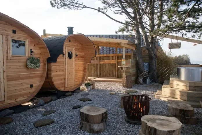Two barrel saunas in a garden by the sea