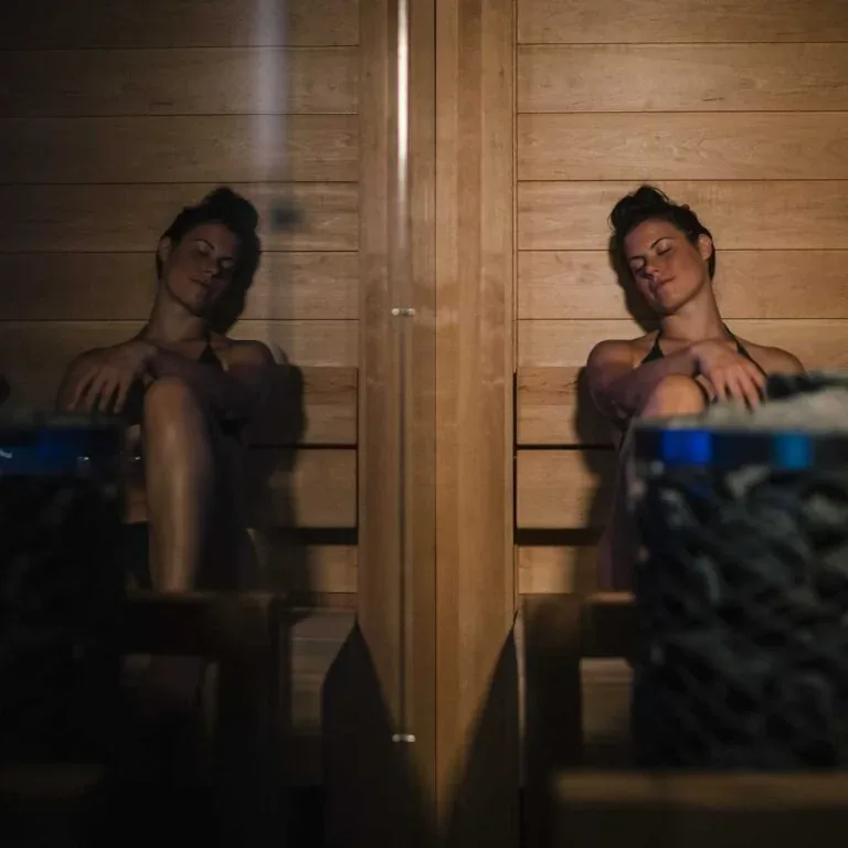 Two people relaxing on a sauna bench