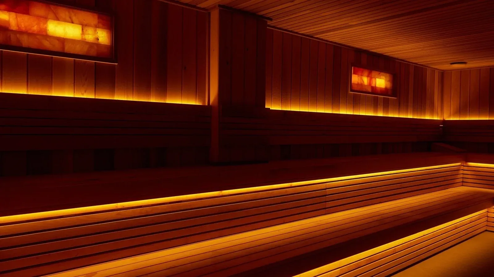 Dark wooden sauna with warm strip lighting