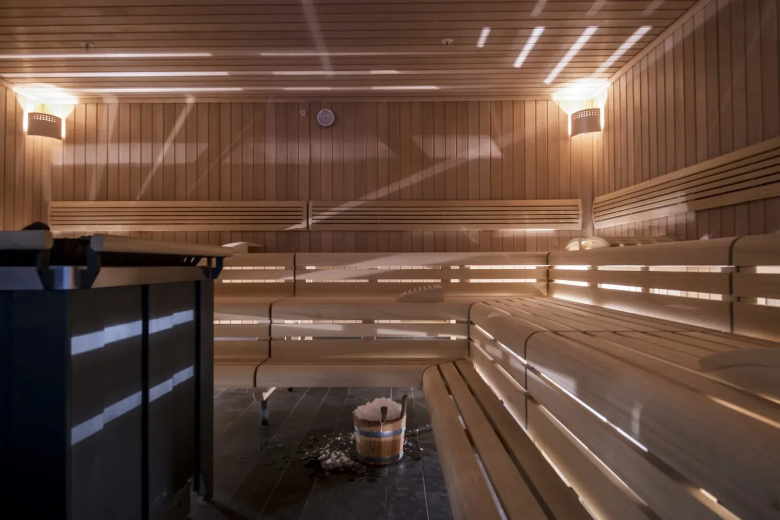 Modern wooden sauna with tiered benches and a heater