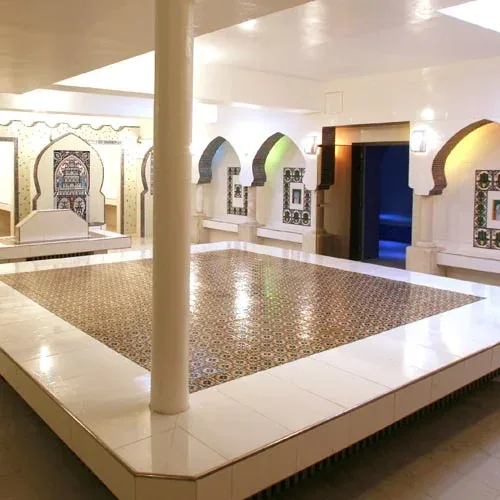 Bright hammam with tiled arches and a central marble platform