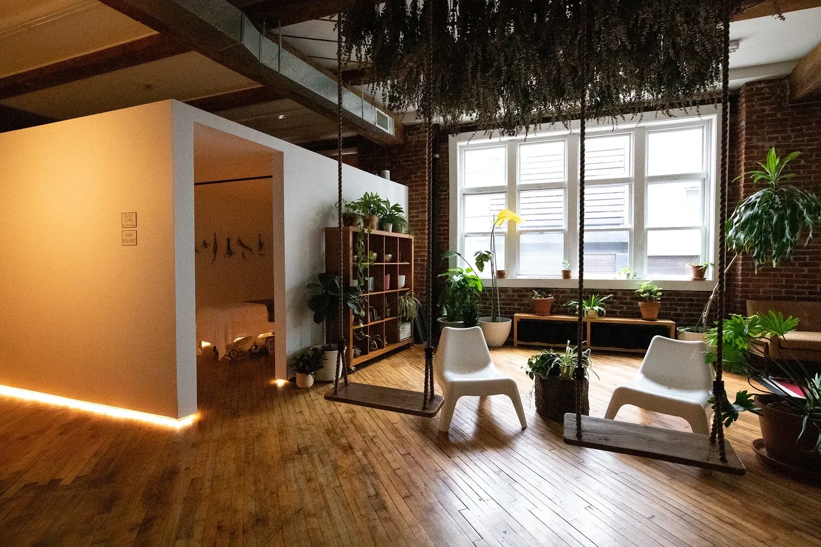 Bright relaxation lounge with plants, chairs and a hanging seat