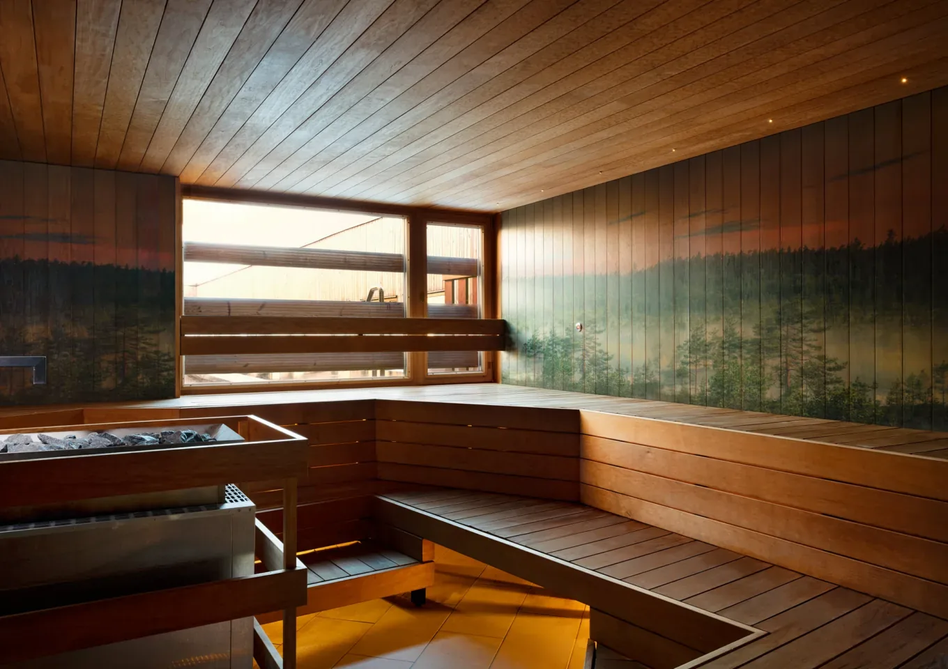 Wooden sauna with benches, a stove on the left and a painted forest mural on the back wall