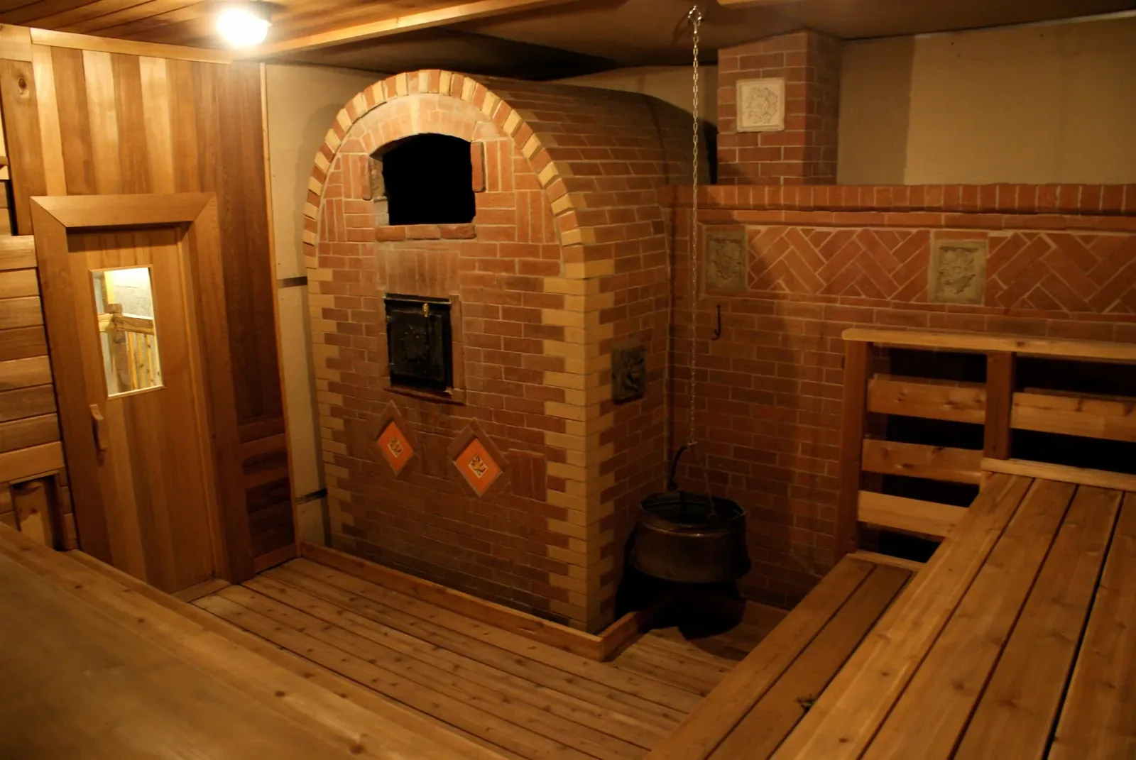 Brick banya stove beside tiered wooden benches