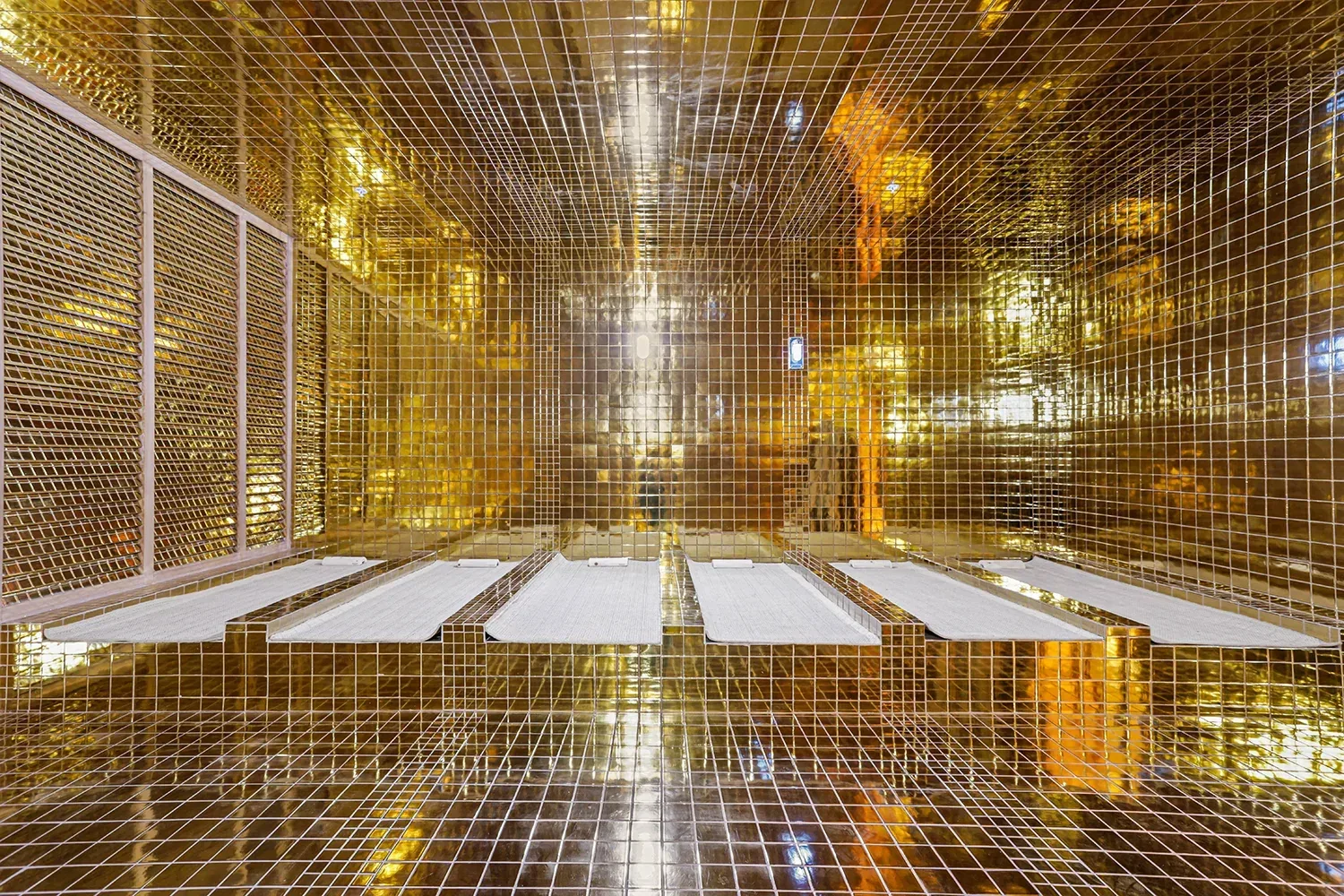 Gold-tiled heated room with mats laid out on the floor